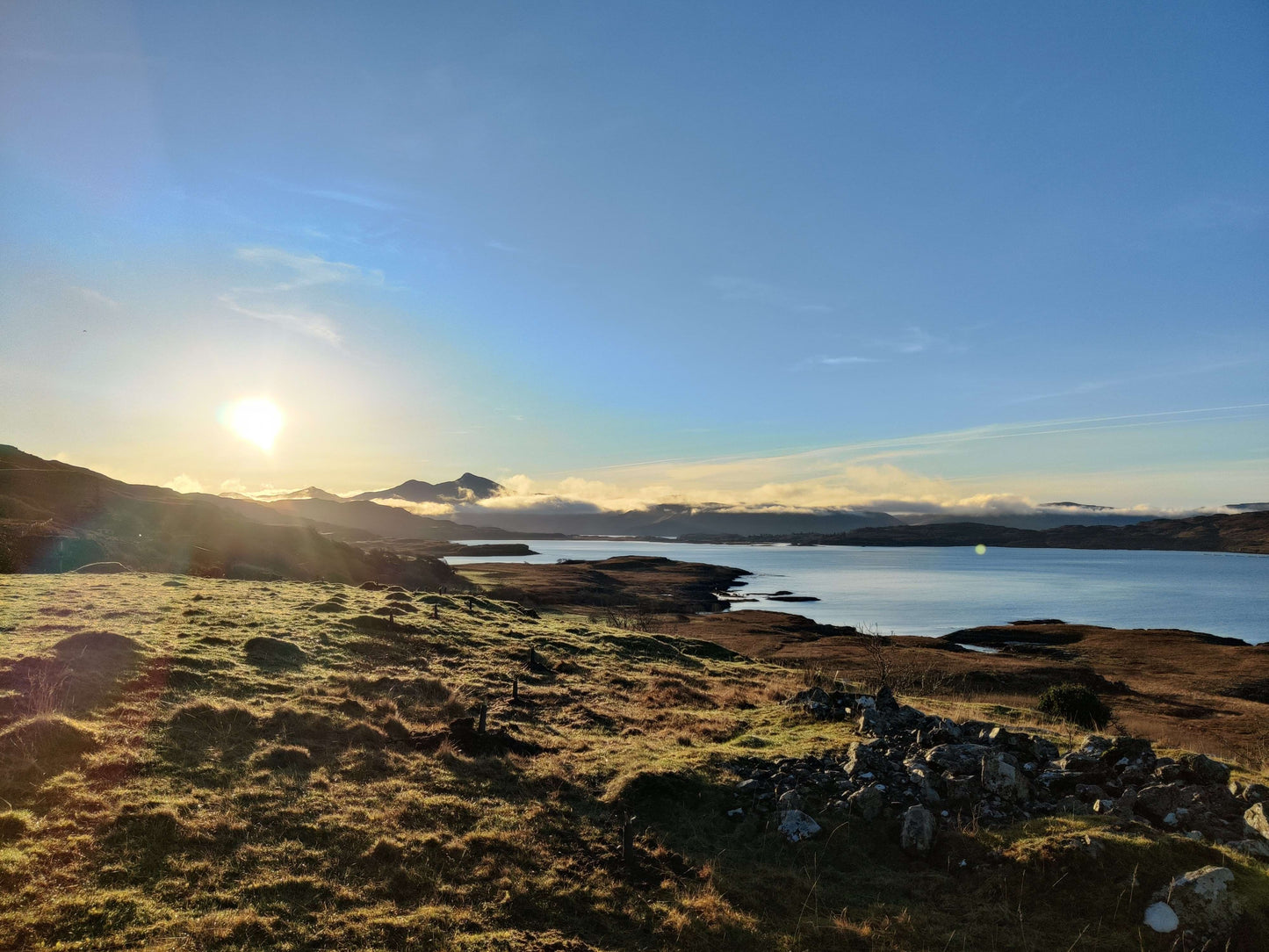 Scenic view of a lake with mountains in the background during sunset.