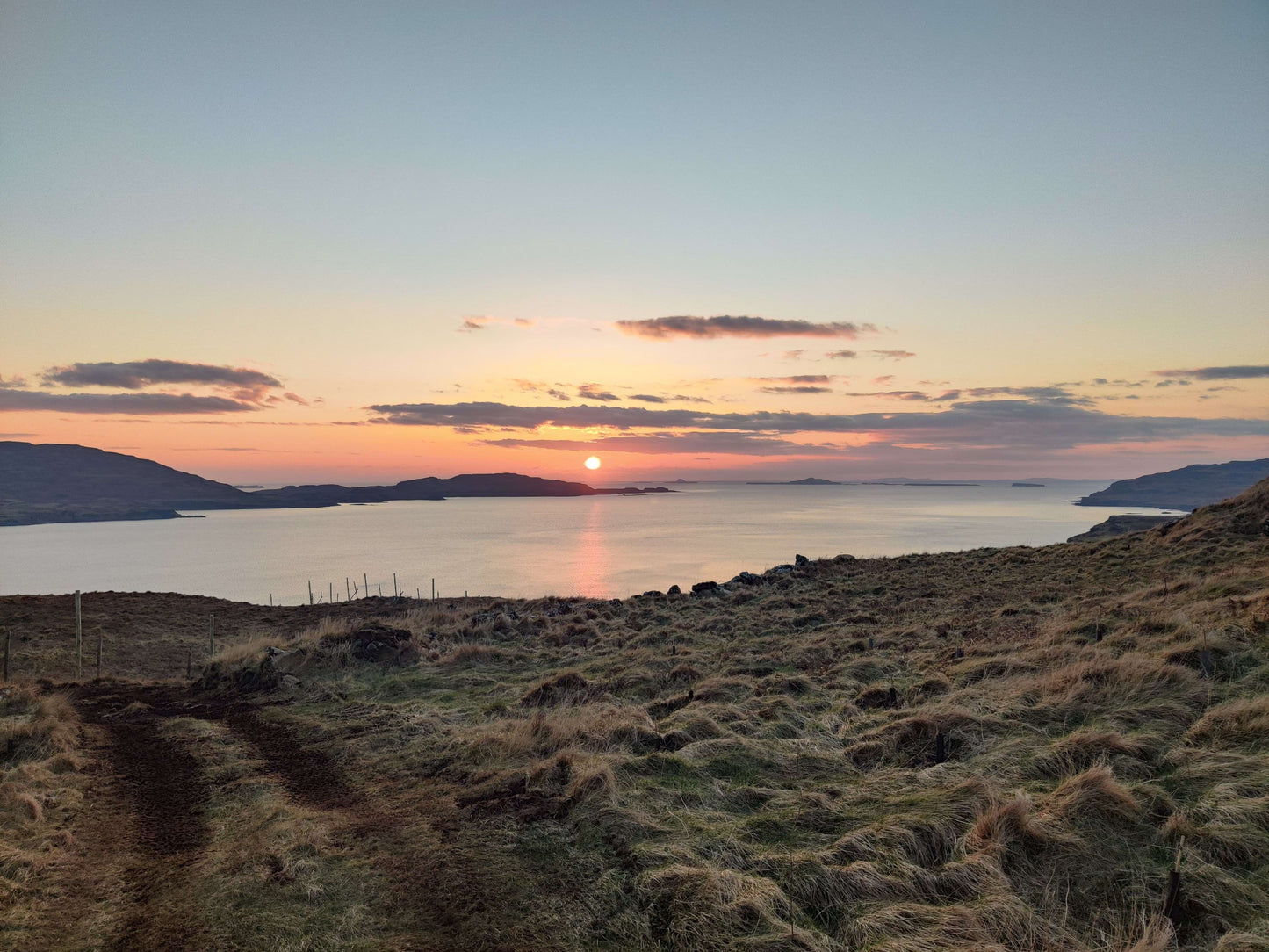 Sunset over a body of water with hills in the background