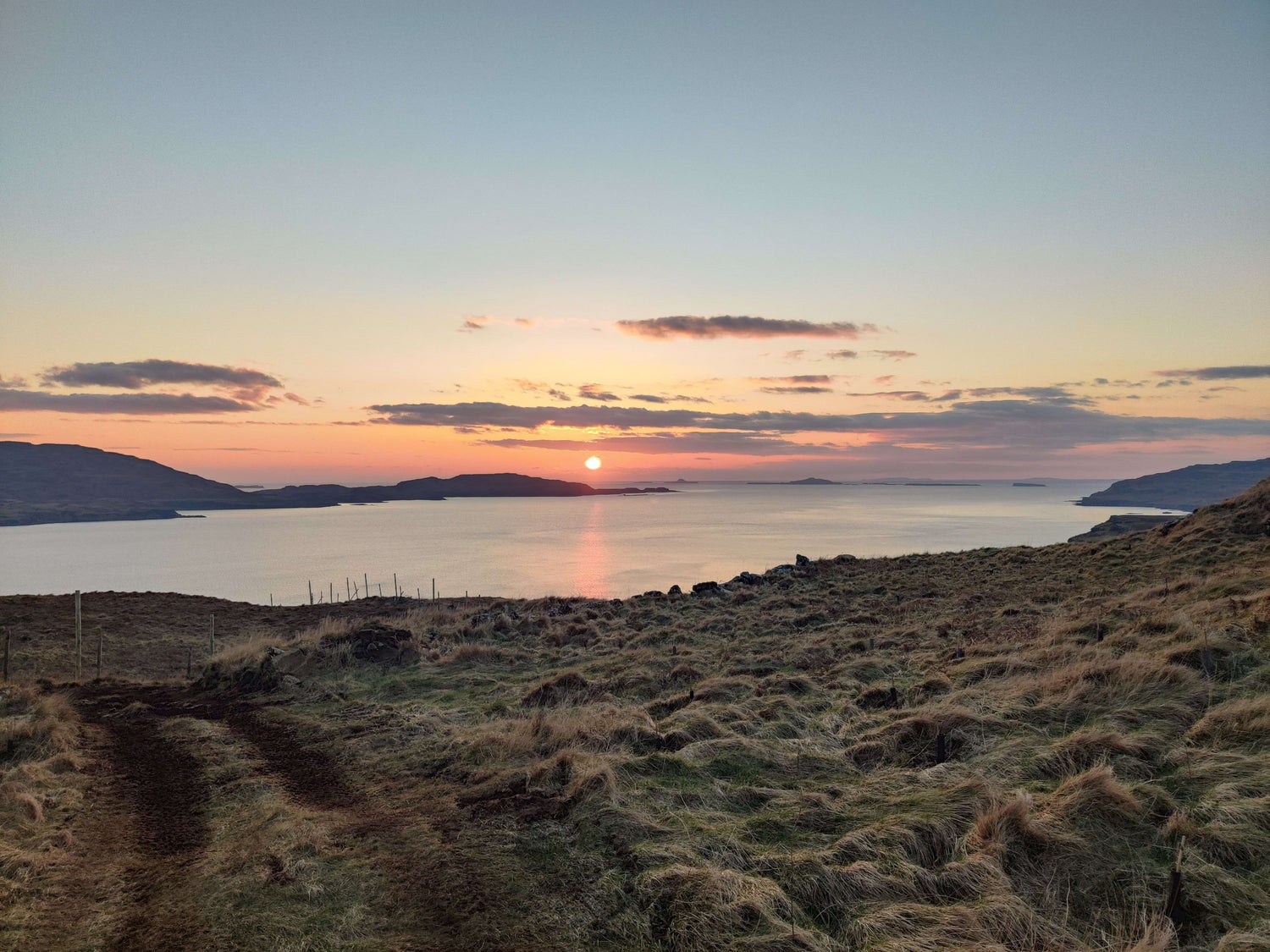 Sunset over a body of water with hills in the background